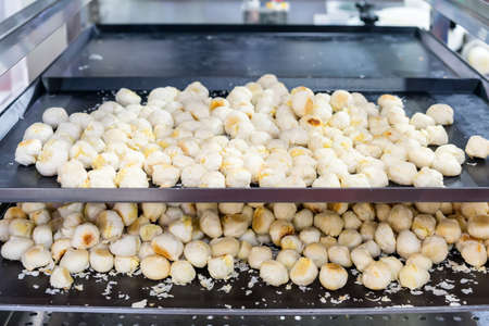 Many colorful and tasty loaf of chinese pastry on tray in shelves of industrial food