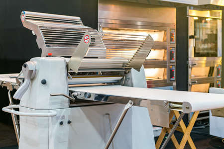 modern and high technology dough sheeter machine for preparing dough and making pastry in industrial food or bakeryの写真素材