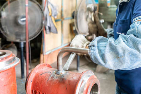 worker or operator cleaning welding seam slag remove by knock with hammer and chisel at factoryの写真素材