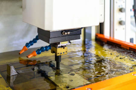 close up workpiece and graphite electrode during working on automatic electrical discharge machine (edm)の写真素材