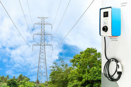 Modern Ev station plug and power cable supply for electric vehicle charging or hybrid car on natural...