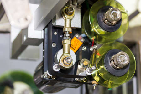 close up detail of roller feed plastic film packaging unit of automatic food packing machine for...