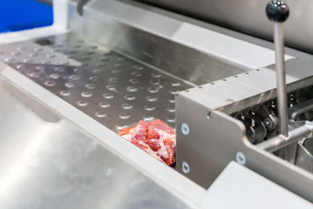 Close up pork or meat sliced on metal rail transport food of automatic and precision slicer machine...