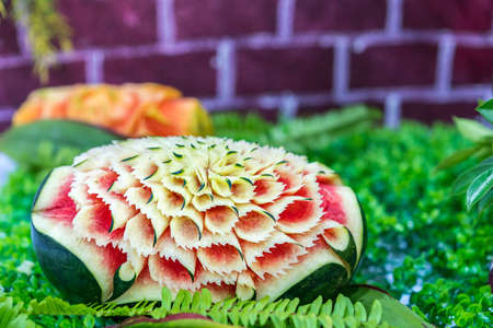 Colorful and beautiful watermelon carved or sculpted on green leafの写真素材