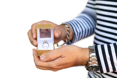 Man proposing and hold box with beautiful and luxury wedding diamond ring on two hand isolated on white background with clipping pathの写真素材