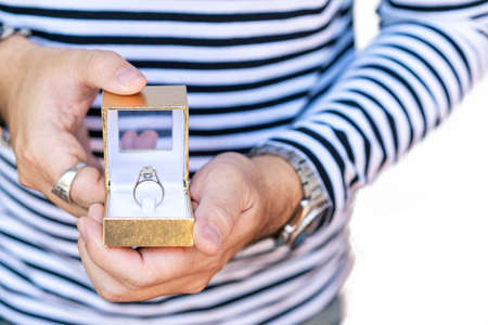 Man proposing and hold box with beautiful and luxury wedding diamond ring on two hand isolated on white background with clipping pathの写真素材