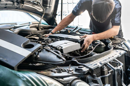 repairman or mechanic during car repair investigate cause of problem (mechanism or combustion system...
