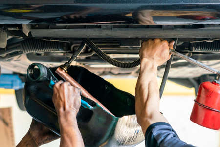 repairman or mechanic during use inject gun flush oil for cleaning in inside cooling tube for modify or development cooling system of automobile gasoline or diesel engine at garageの写真素材