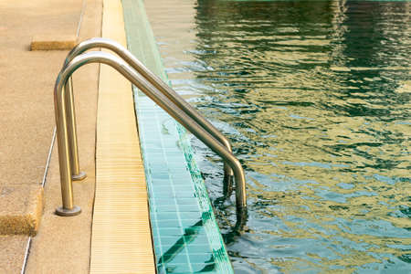 metal staircase in school swimming pool with sunny reflections