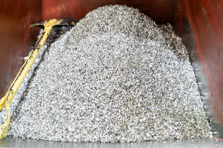 Many bulk aluminum machine scrap or chips from manufacture process with shovel in steel box for recycleの写真素材