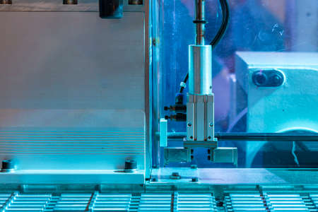 Automation system robot arm with grip during process sorting lift and place or moving work piece on work table in industrial on blue toneの写真素材