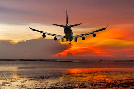 rear view commercial passenger aircraft or cargo transportation airplane fly over coast of sea after...