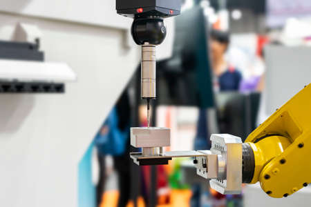 automatic coordinate measurement machine (CMM) during inspection precision part of engine for industrial in manufacturing process with robot arm and auto grip clamp for transferの写真素材