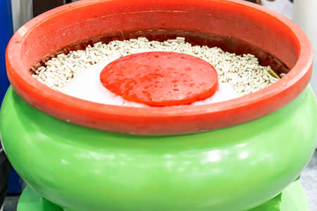 Stone or ceramic tumbling media in batch of vibratory polishing machine for manufacturing mass...