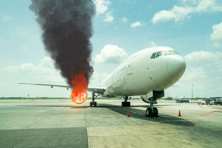 passenger aircraft or cargo airplane parking at terminal gate of international airport on was on fire or burns down at the jet engine in daytimeの写真素材
