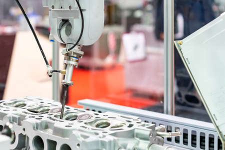 high technology accuracy and modern automatic picking by vacuum or suction during assembly intake & exhaust valve with cylinder head engine or parts product of manufacturing process in industrialの写真素材