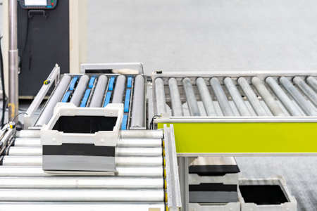 Empty plastic box on roller conveyor of automatic production line of manufacturing process for transportation material goods or product etc. in industrialの写真素材