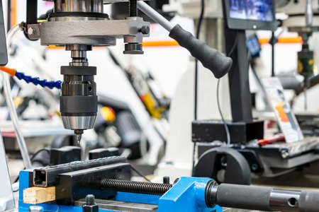 flow drill, or friction drilling tungsten carbide cutting tools hold by spindle collet chuck holder with square tube workpiece during hole making for thread tapping by vertical table drilling machineの写真素材