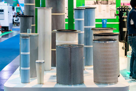 Various size and type air pleated filter paper for cleaning air or gas fluids or remove dust debris contaminants in engine or machine of industrial work on tableの写真素材