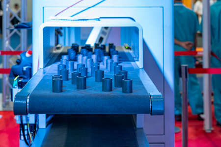 Many metal short pipe product or workpiece on automatic belt conveyor during manufacturing processの写真素材