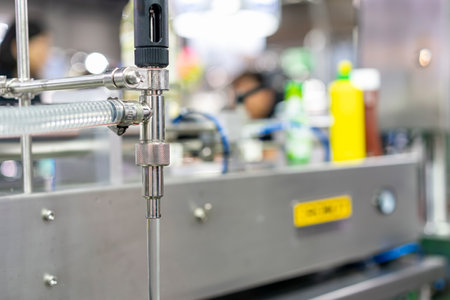 Water flow out of stainless steel tube nozzle component of automatic liquid filling or dispenser in...