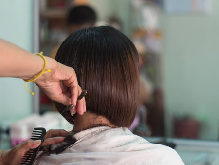 Hair stylist trimming short hair young asian woman at beauty salon.の写真素材