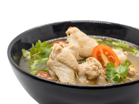 Hot and spicy chicken soup in black bowl on white background, Thai food Tom Yum, Chicken Tom Yum is thai delicious food.の写真素材