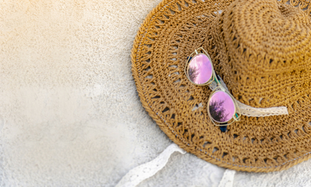Hats and glasses are located on the beach, blue sea, during the day of relaxing or long holidays.の写真素材