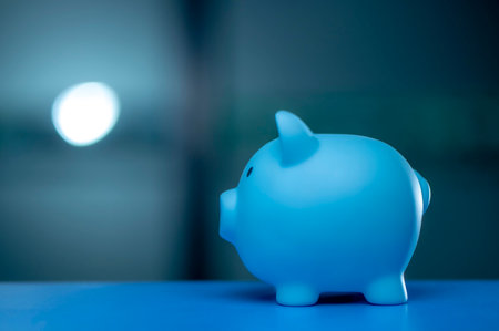 A hand is dropping coins into a piggy bank. The concept of saving and investing.の写真素材