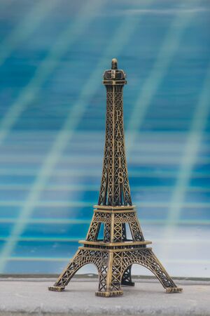 Little model of Eiffel tower and swimming pool background with vintage effect.の写真素材