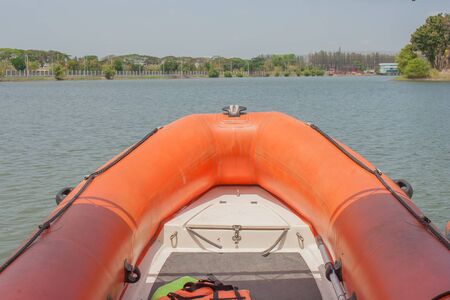 Orange rubber boat on lake at public park.の写真素材