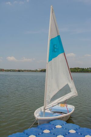White sailboat dock on lake at public park.