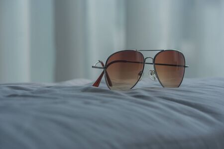 Relaxation Concept : Sunglasses on bed in the bedroom at the resort.の写真素材