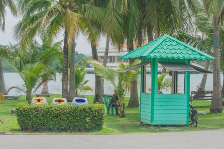 Rest home of guard security staff with coconut palm trees background in public park.の写真素材
