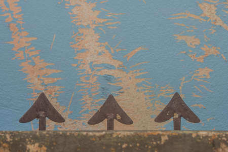 Abstract image arrow head shape of steel fence and blue grunge wall background.の写真素材