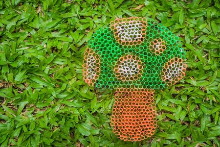 Close up colorful mushroom on green grass handmade with plastic straw.の写真素材