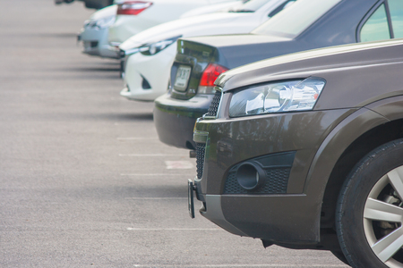 Row of several car parked on parking lot at public park.の写真素材