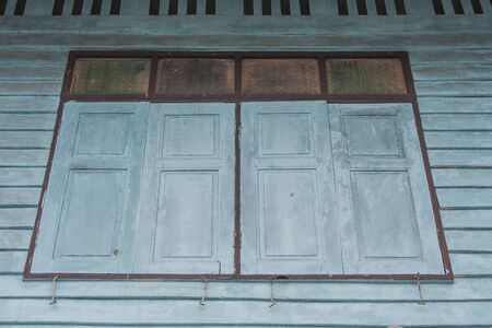View of wooden window on vintage wall of old wooden house at countryside in vintage style.の写真素材