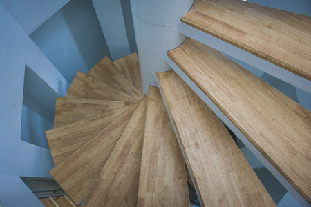 Top view of spiral wooden staircase with blue wall.の写真素材