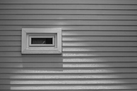 View of wooden window on gray wall of wooden house at countryside in vintage style.の写真素材