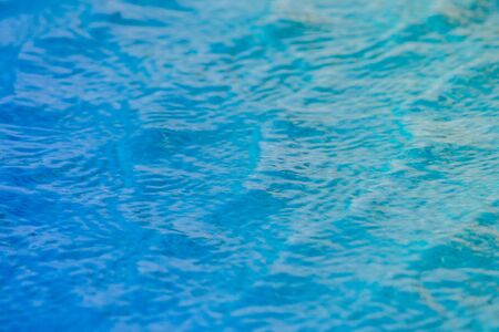 Close up of sparkling blue water with wave surface in swimming pool. (Selective Focus)の写真素材