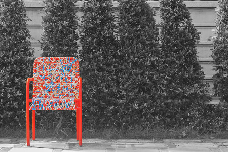Abstract colorful plastic weaving rattan chair standing on concrete floor with black and white background.の写真素材