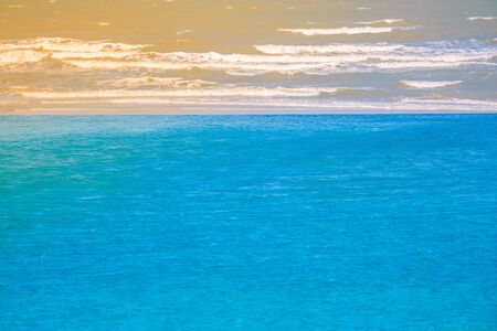 Blue water in swimming pool at the resort with sea view and sunlight background in vintage style. (Selective Focus)の写真素材