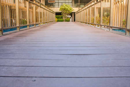 Wooden walkway cross over swimming pool at outside the resort. (Autumn filter effect)の写真素材
