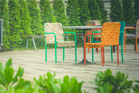 Abstract colorful plastic weaving rattan chair standing on concrete floor. (Vintage filter effect)の写真素材