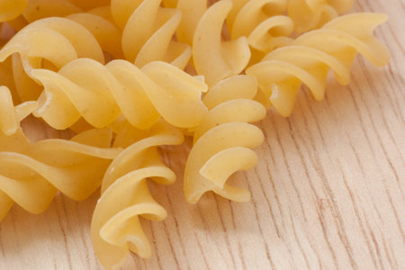 uncooked great italian fusilli on wooden cutting boardの写真素材