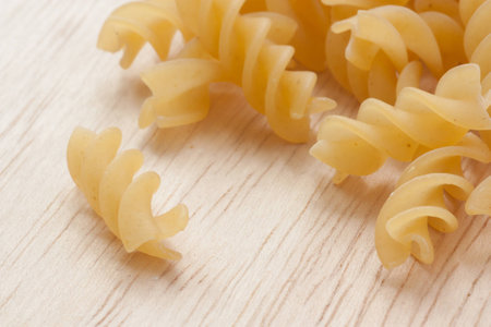 uncooked great italian fusilli on wooden cutting boardの写真素材