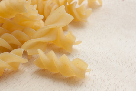 uncooked great italian fusilli on wooden cutting boardの写真素材
