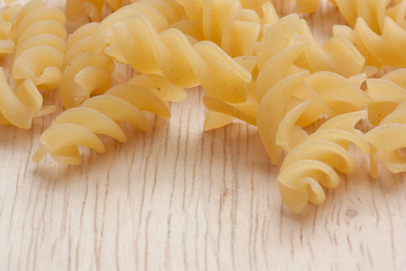 uncooked great italian fusilli on wooden cutting boardの写真素材