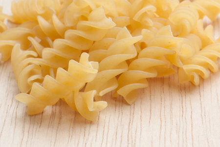 uncooked great italian fusilli on wooden cutting boardの写真素材